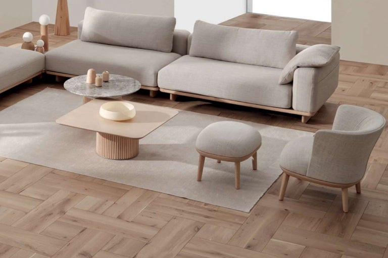 Wohnzimmer mit Ecksofa, Sessel, Hocker, Couchtisch und Teppich