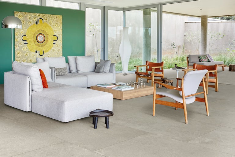 Wohnzimmer mit Sofa, Stühlen und Fliesenboden