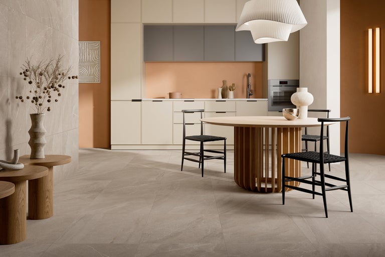 Heller Raum mit Fliesenboden, Esstisch und Küchenzeile