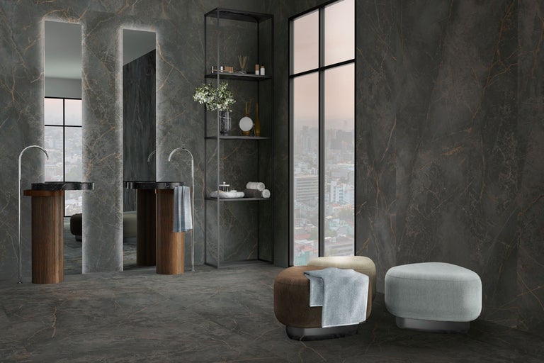 Modernes Badezimmer mit großformatigen Wand- und Bodenfliesen in dunkler Marmoroptik, zwei Waschbecken mit Holzsockel und hohen Spiegeln.