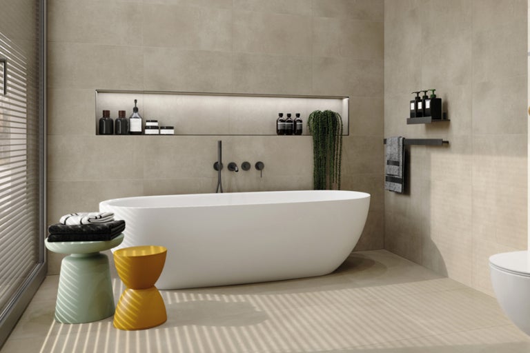 Helles Badezimmer mit freistehender Badewanne, Ablageflächen und passenden Fliesen für Boden und Wände.