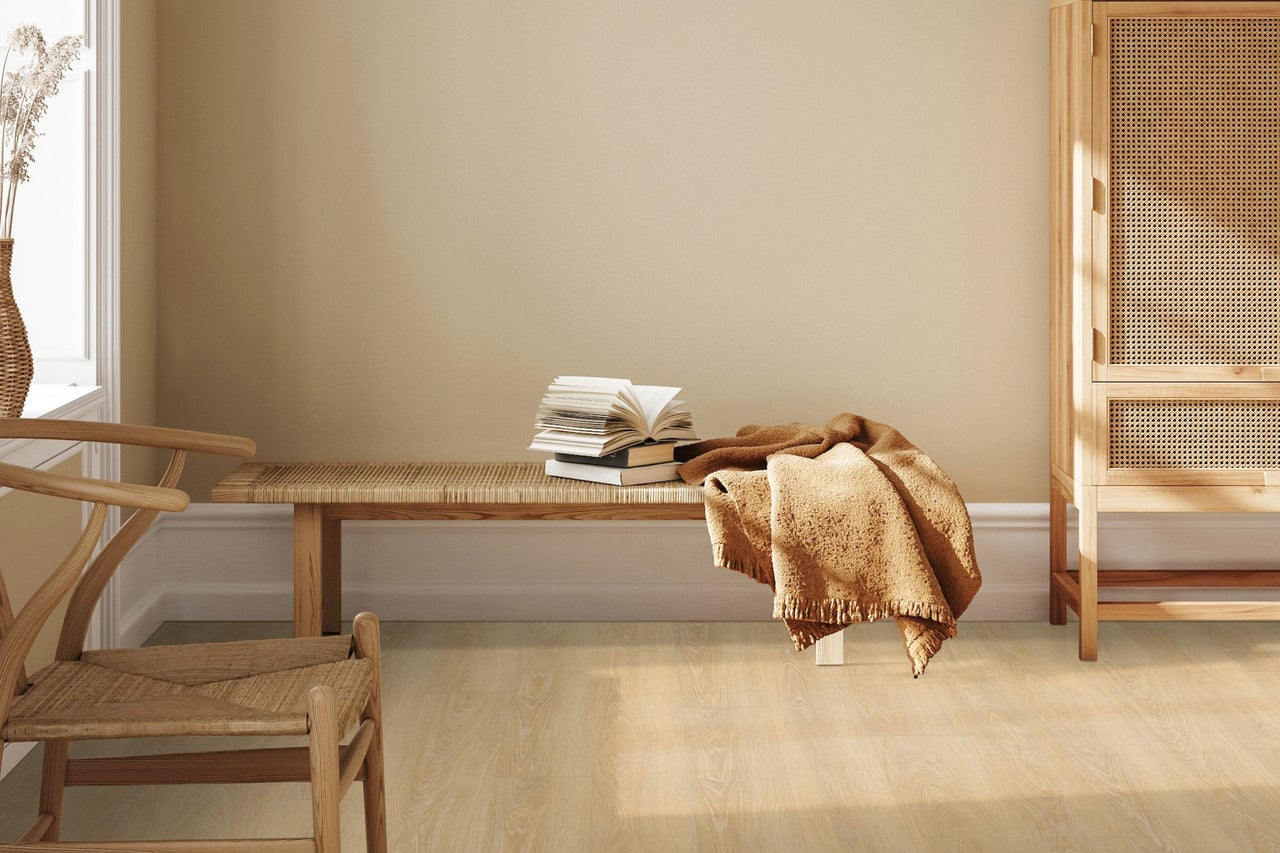 Innenraum mit Holzmöbeln, Bank mit Büchern und Decke, Stuhl, Schrank mit Rattangeflecht