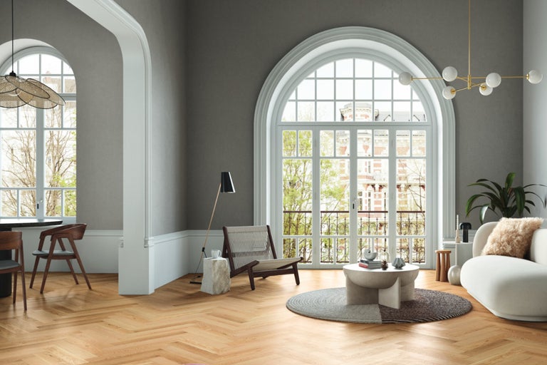 Heller Wohnraum mit Holzboden, großem Fenster und modernen Möbeln