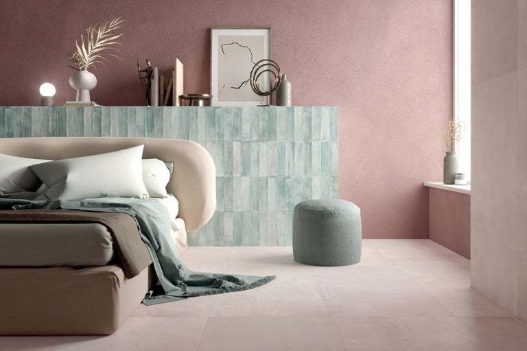 Schlafzimmer mit Bett, Nachttisch, Hocker und Bodenfliesen