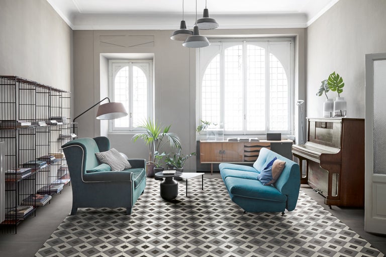 Wohnzimmer mit Couch, Sessel, Piano und Bodenfliesen in geometrischem Muster