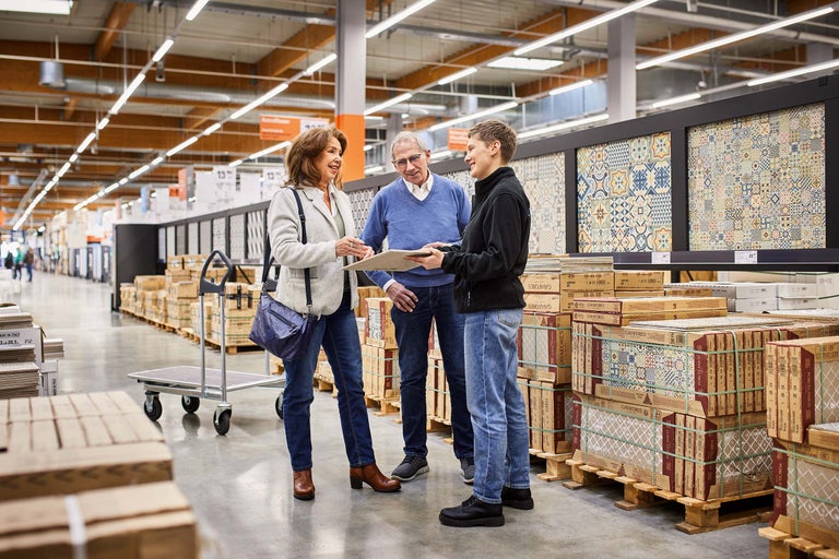 Kunden besprechen Fliesen mit einem Hornbach Mitarbeiter im Markt.