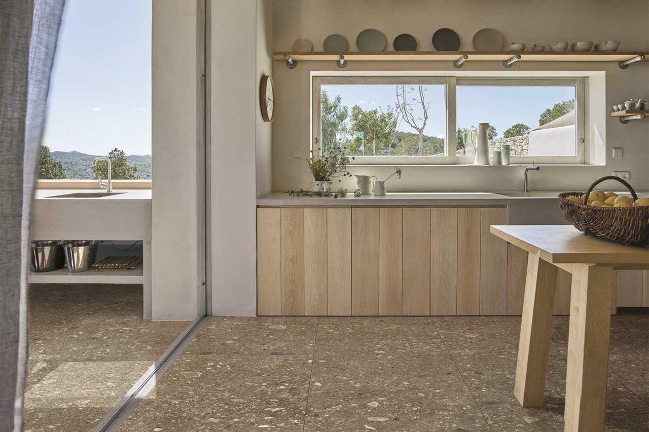 Helle Küche mit Fensterblick, Holzelementen und Bodenfliesen