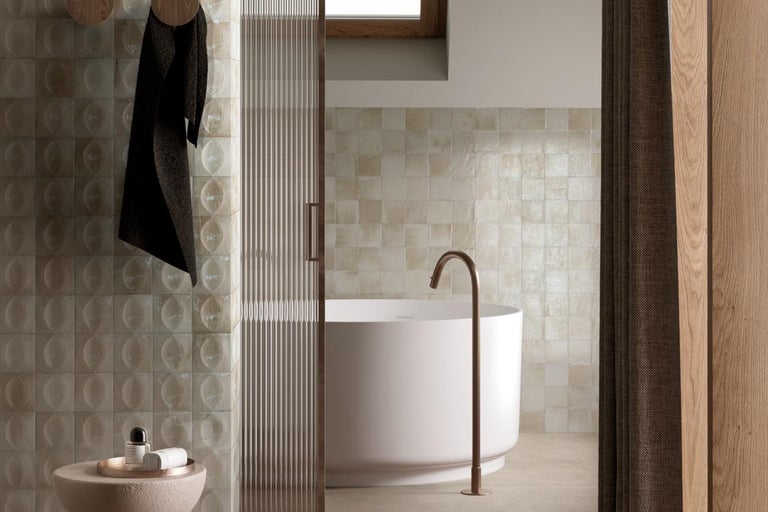 Badezimmer mit Badewanne, Fliesen und Handtuch