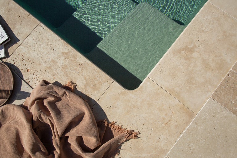 Pool mit Travertinfliesen und Badetuch