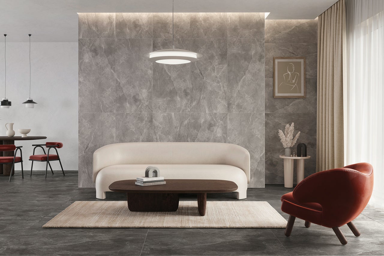 Heller Wohnraum mit Sofa, Sessel, Tisch, Teppich und Steinfliesen