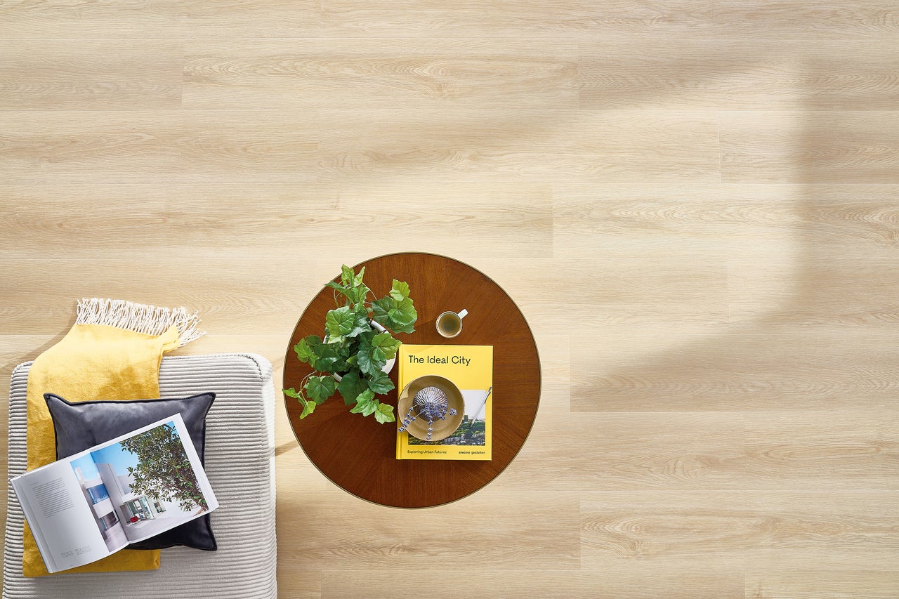 Heller Holzboden mit Couch, Tisch und Dekoration von oben