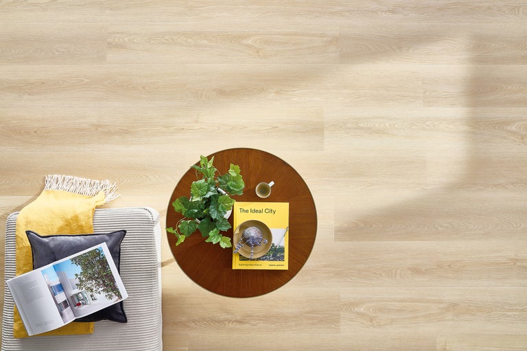 Heller Holzboden mit Couch, Tisch und Dekoration von oben