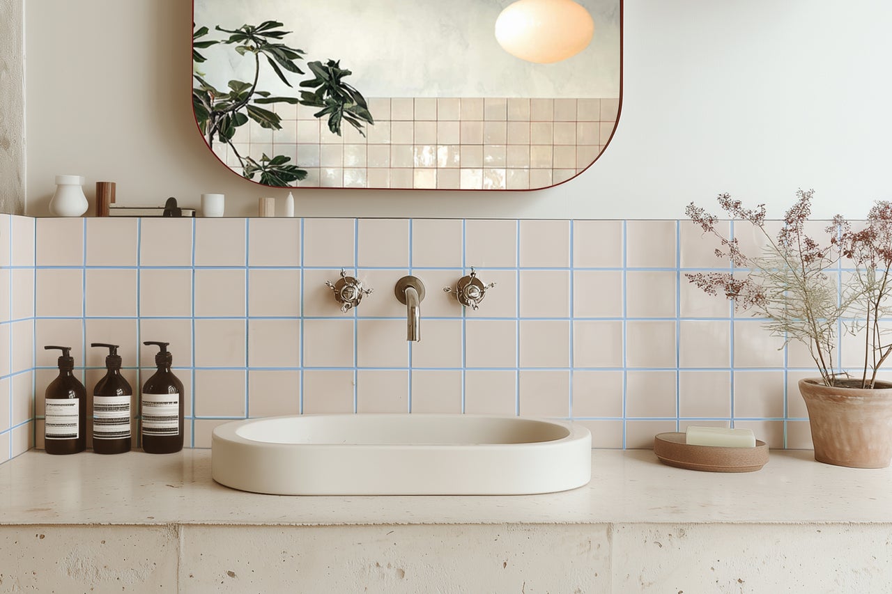 Badezimmer mit Aufsatzwaschbecken, Armaturen, Spiegel und Fliesen