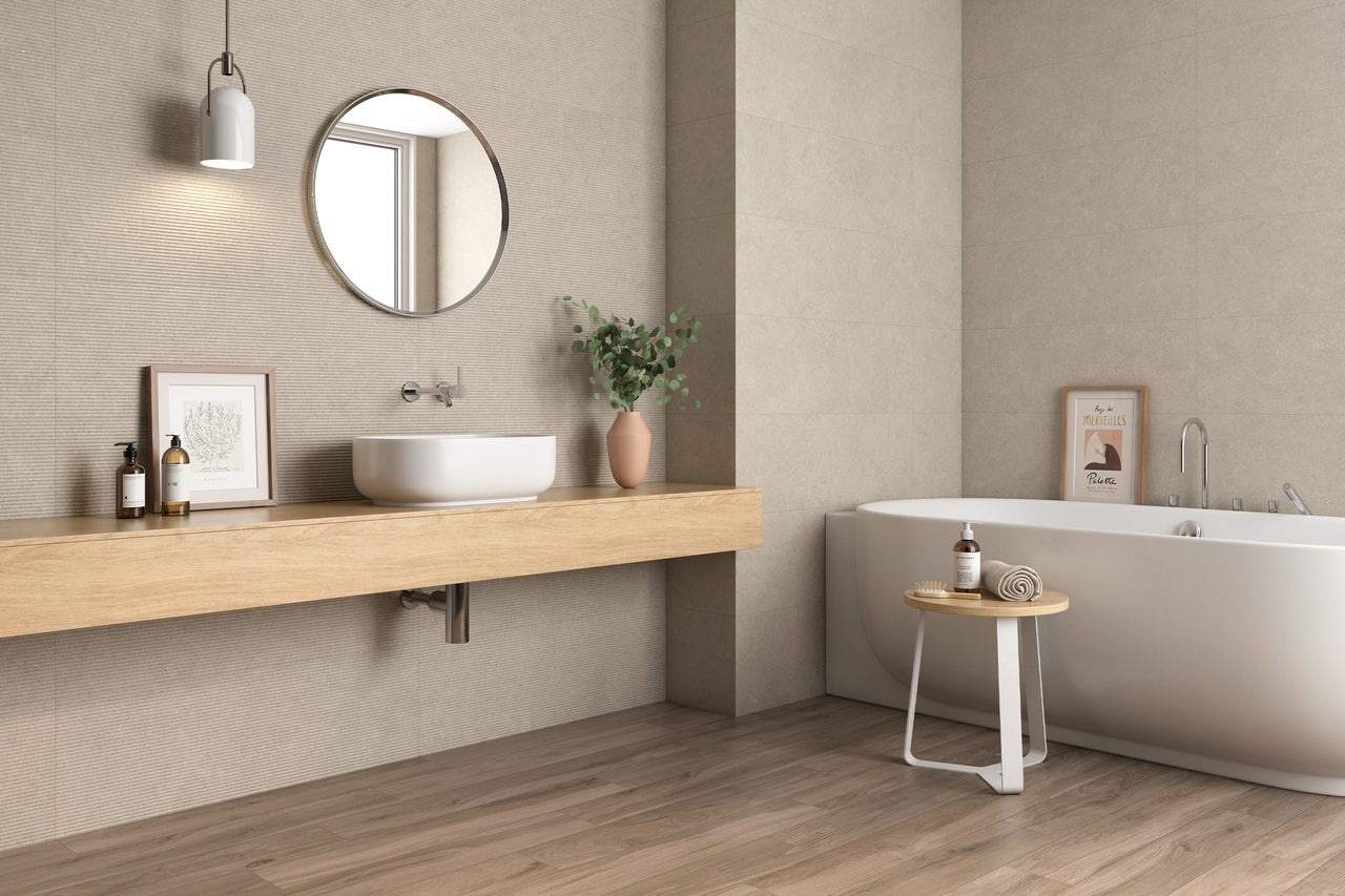 Badezimmer mit Badewanne, Waschtisch, Spiegel und Holzfußboden