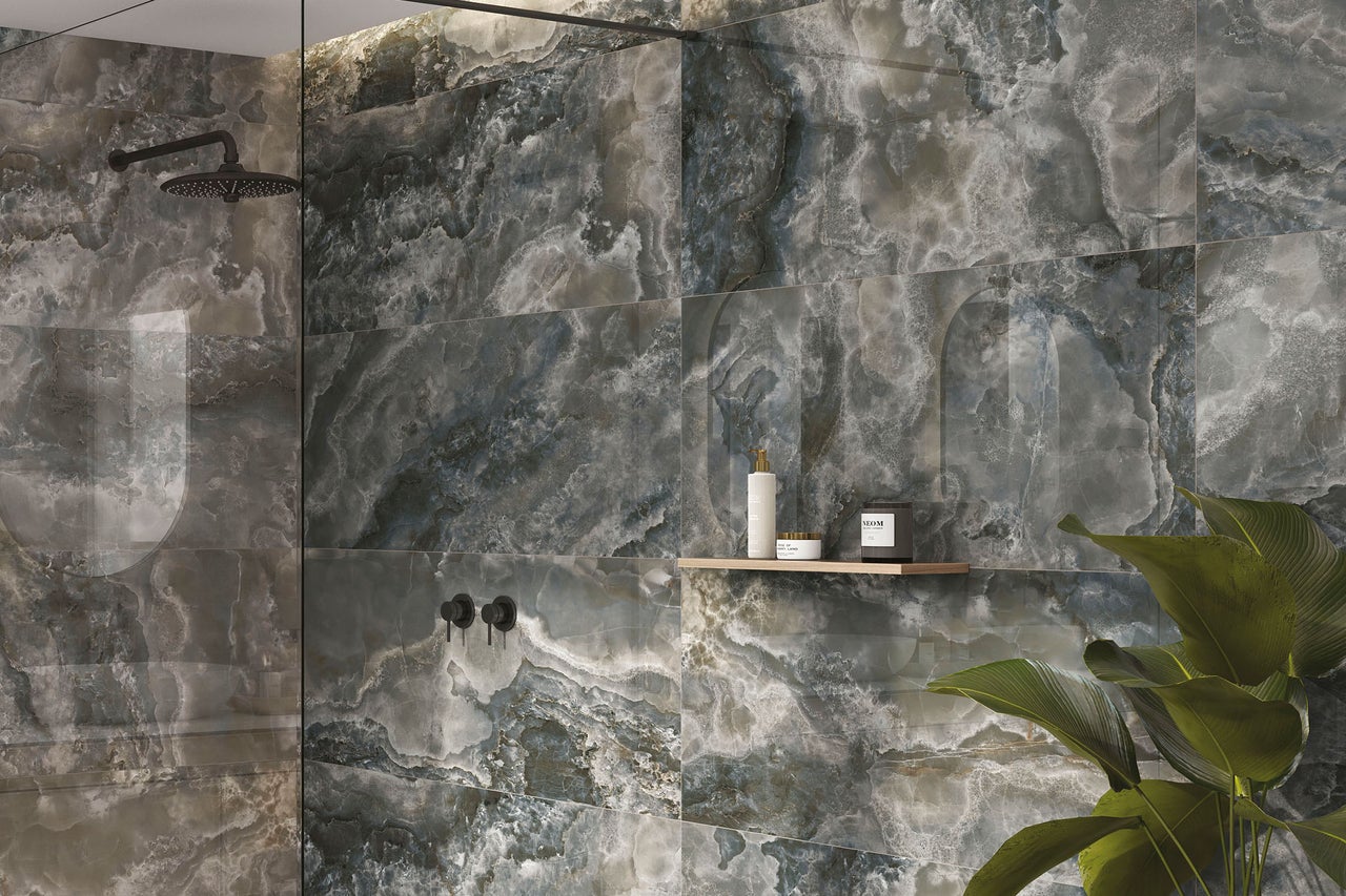 Modernes Badezimmer mit großformatigen Wandfliesen in Onyx-Optik, einer schwarzen Regendusche und Holzelementen.