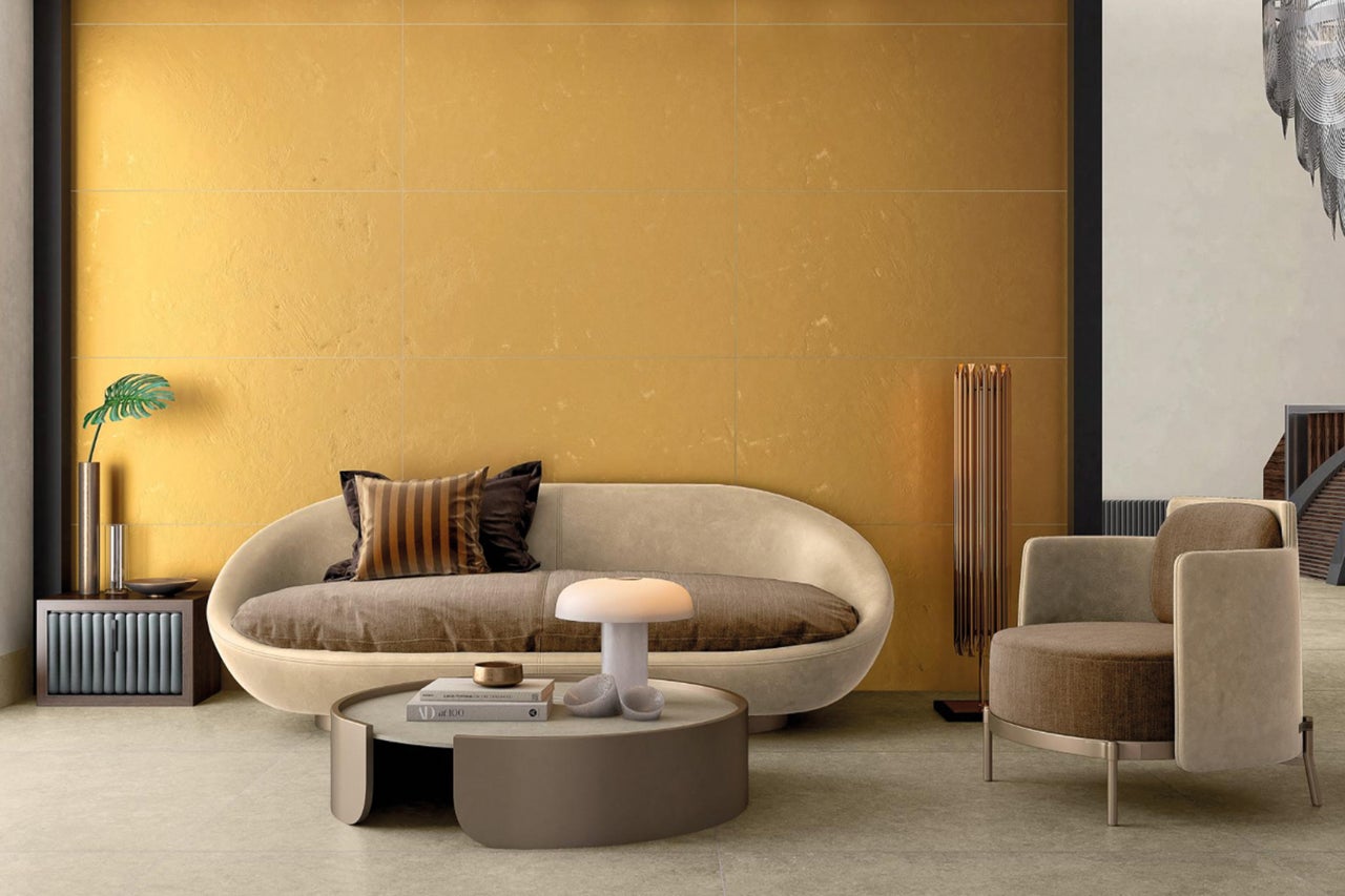 Wohnzimmer mit Fliesenwand, Sofa, Sessel und Beistelltisch