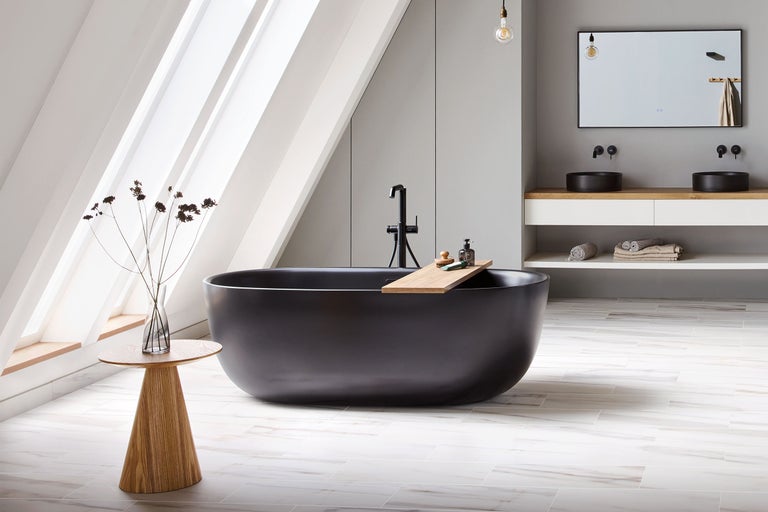 Modernes Badezimmer mit freistehender schwarzer Badewanne, Doppelwaschtisch mit Aufsatzbecken, Holzdetails und hellen Fliesen in Marmoroptik.