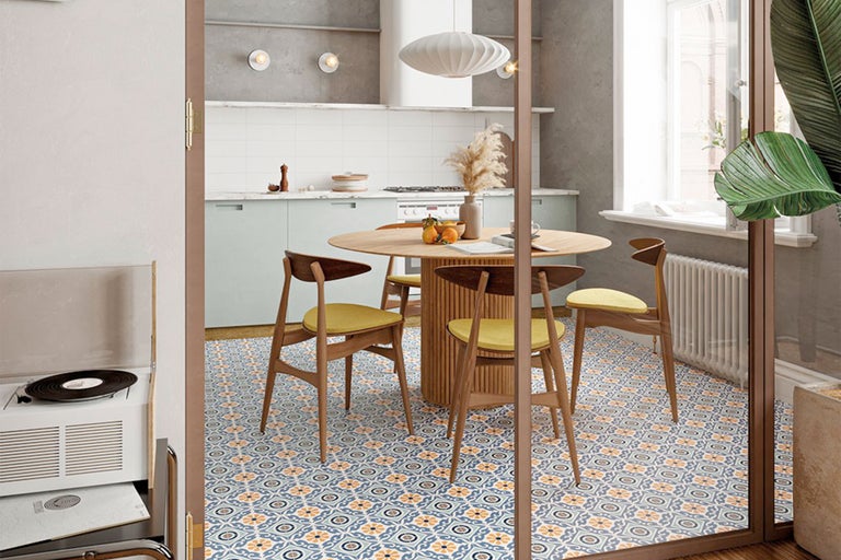 Esszimmer mit rundem Holztisch, Stühlen und gemusterten Fliesen.
