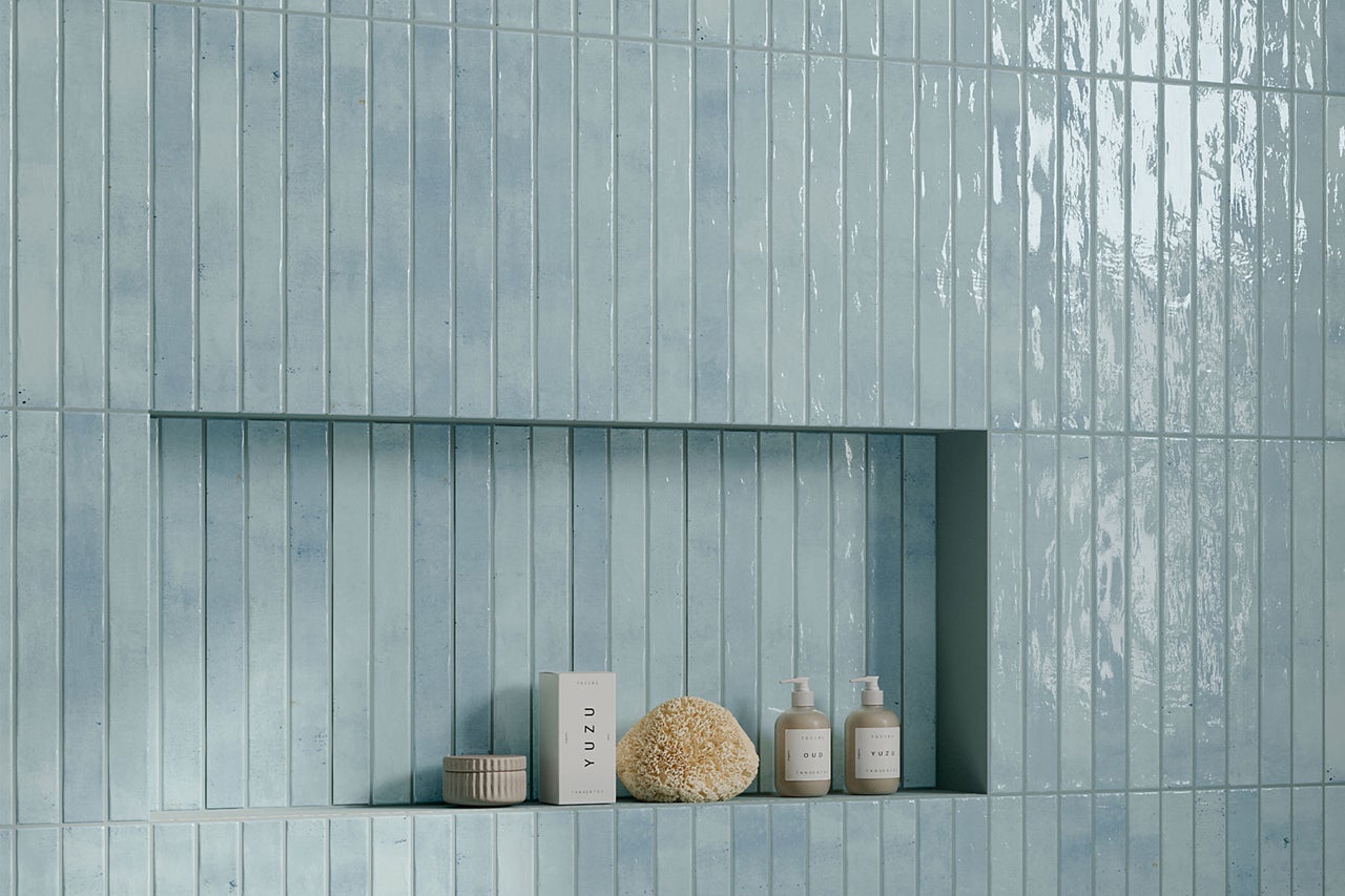 Badezimmerwand mit schmalen Fliesen und Ablagefläche für Badutensilien