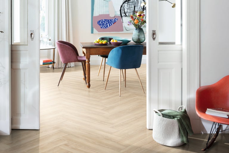 Esszimmer mit Holztisch, Stühlen und hellem Fischgrätparkettboden