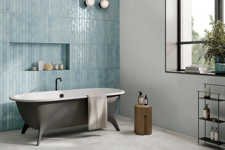 Badezimmer mit Badewanne, Wandfliesen und Möbeln