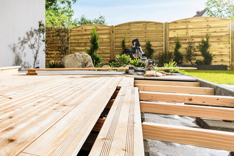 Aufbau einer Holzterrasse im Garten mit einer Kappsäge.