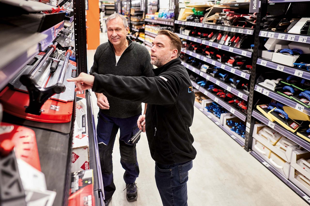 Zwei Personen betrachten Fliesenschneider im Hornbach Markt.