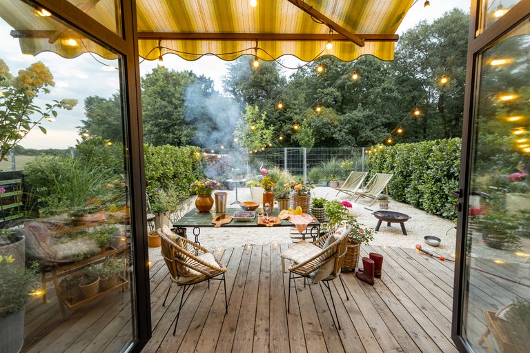 Außenbereich mit Gartenmöbeln, Grill und Beleuchtung für Gartenparty