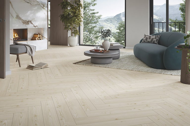 Heller Wohnraum mit Fischgrätparkett, Kamin und Sofa