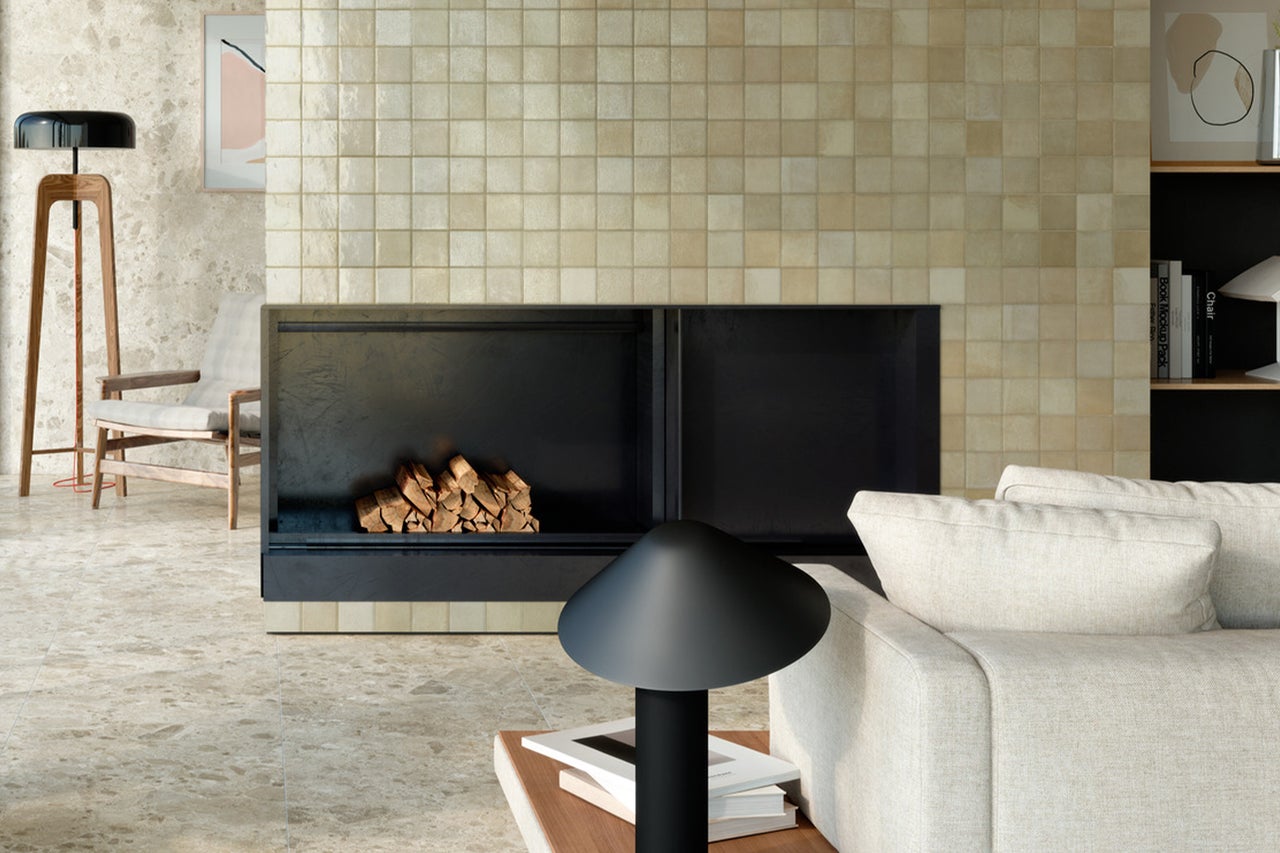 Wohnzimmer mit Kamin, gefliesten Wänden und Boden, Sofa und Lampe