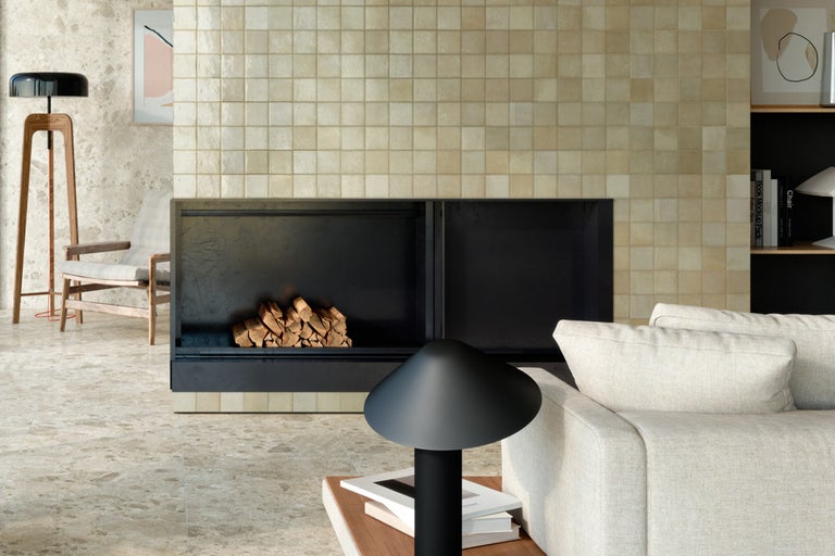 Wohnzimmer mit Kamin, gefliesten Wänden und Boden, Sofa und Lampe