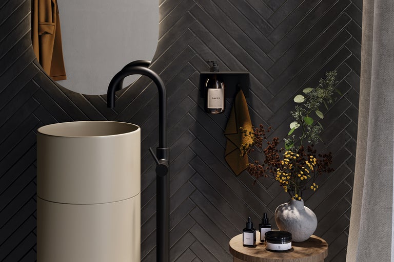 Modernes Badezimmer mit Waschtisch, Armatur, Spiegel und dunklen Fliesen im Fischgrätmuster.