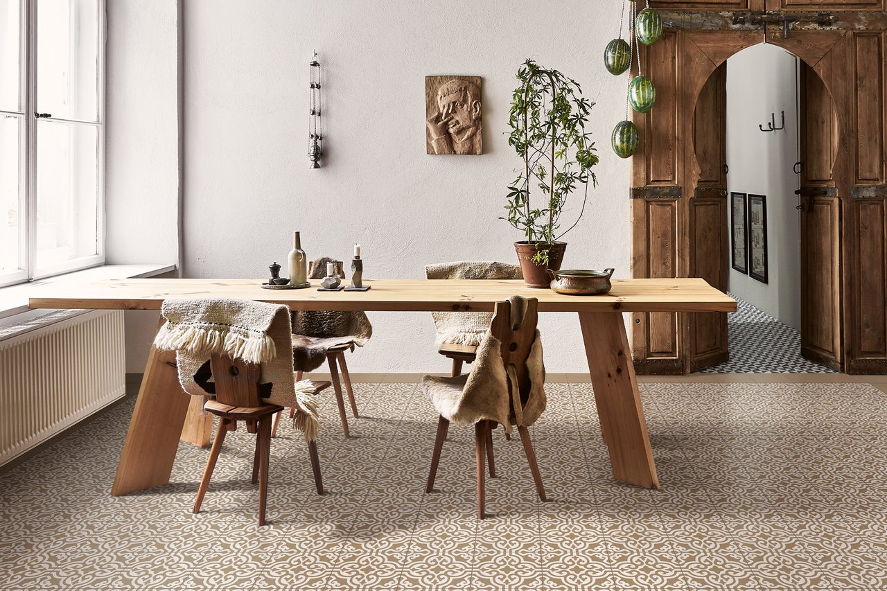 Heller Raum mit Holztisch, Stühlen mit Fellen, Dekoration und gemustertem Boden