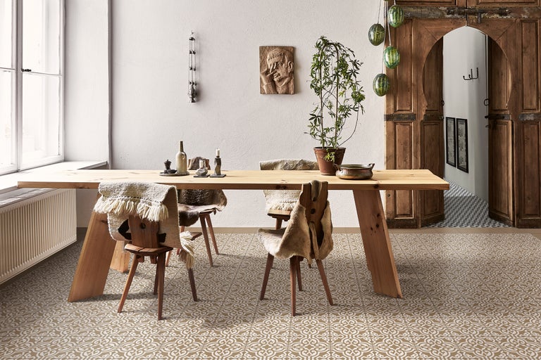 Heller Raum mit Holztisch, Stühlen mit Fellen, Dekoration und gemustertem Boden