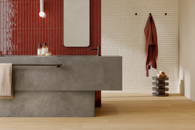 Modernes Badezimmer mit roten und hellen Wandfliesen, Waschtisch und Spiegel.