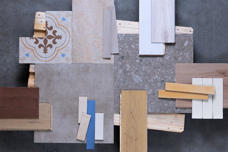 Auswahl an verschiedenen Bodenbelägen und Fliesenmustern auf Holzpalette