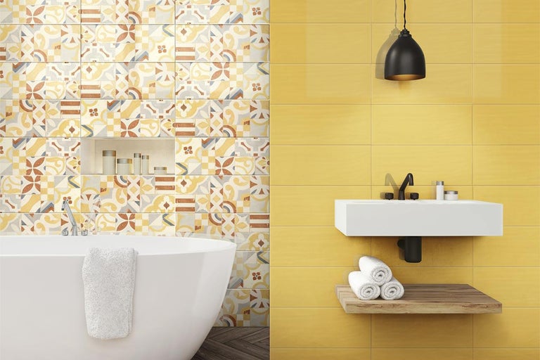 Badezimmer mit Badewanne, Waschbecken und gelben Fliesen