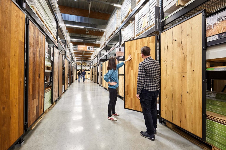 Kunden betrachten eine Auswahl an Holzfußböden im Hornbach Markt.