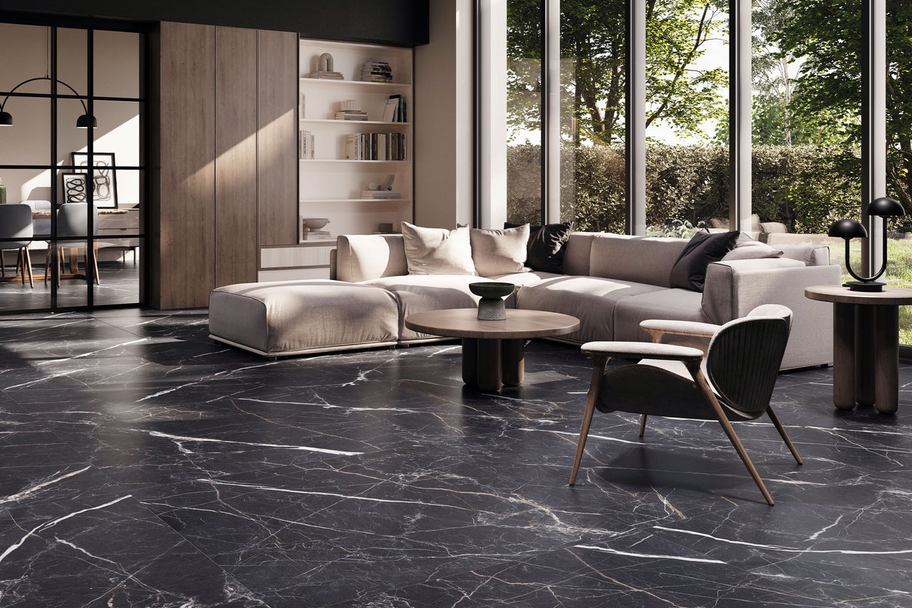 Modernes, helles Wohnzimmer mit dunklen Bodenfliesen in Marmoroptik mit weißer Maserung, hellem Ecksofa und bodentiefen Fenstern.