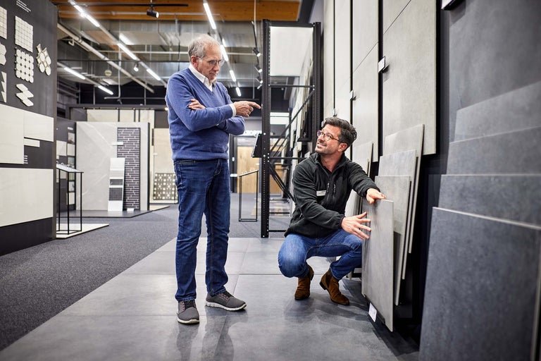 Kunde und Verkäufer begutachten Fliesen im Hornbach Markt.