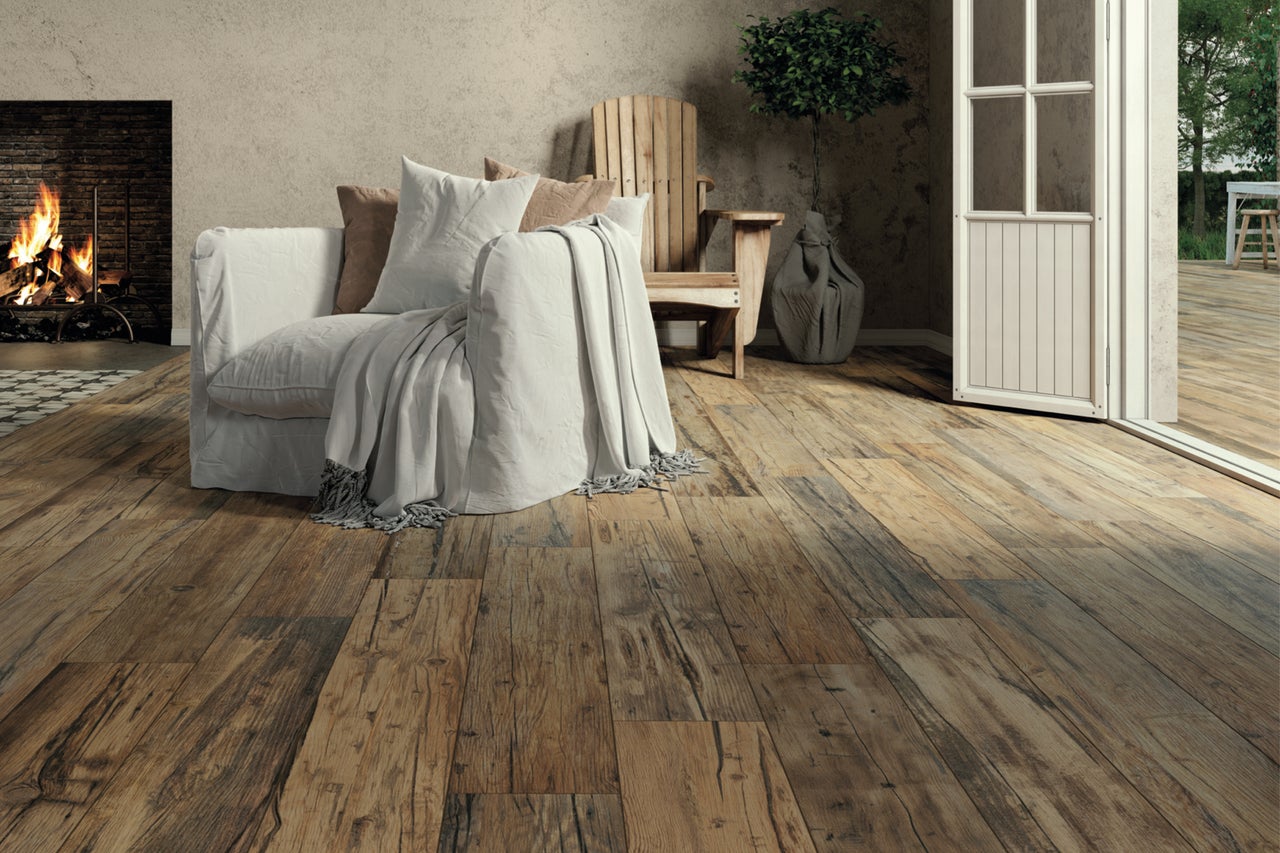 Wohnzimmer mit Holzboden, Sessel und Kamin