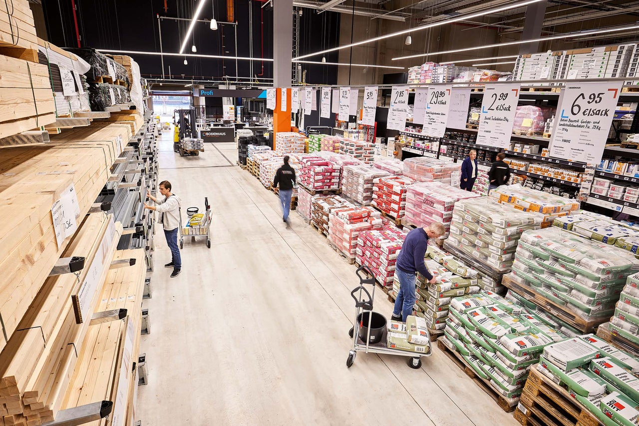 Innenansicht eines Hornbach Baumarktes mit Kunden und Waren wie Holz und Zementsäcken