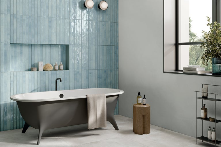 Helles Badezimmer mit Badewanne, blauen Fliesen und dekorativen Elementen für eine stilvolle Einrichtung.