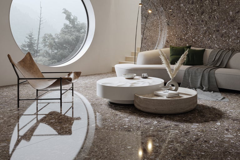 Helles Wohnzimmer mit Sessel, Couch, Couchtischen und großem runden Fenster